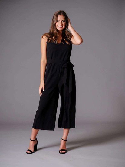 A young woman models a black jumpsuit from a spring boutique clothing collection.