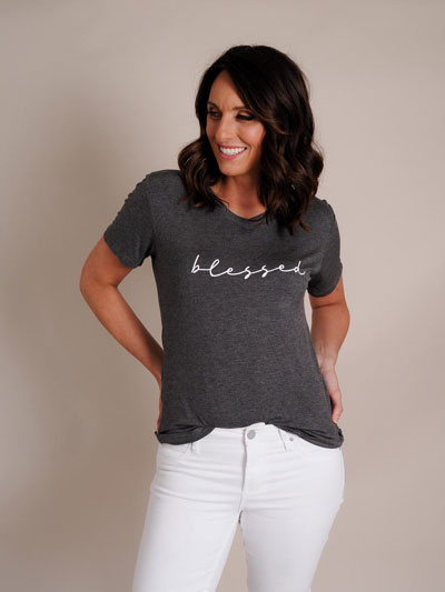 Woman models how to wear “Blessed” graphic tee professionally.