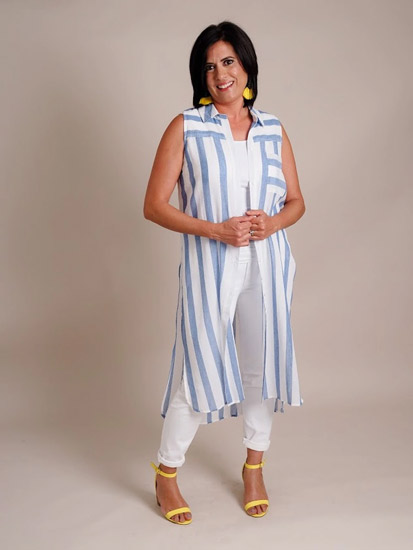 A woman models blue and white spring boutique clothing.