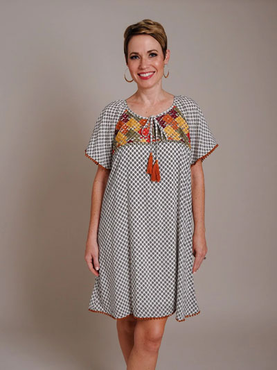 A woman models a bohemian embroidered casual boutique dress.