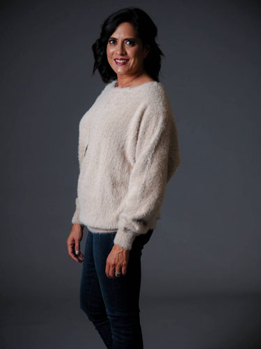 A woman models a cute, fuzzy winter sweater. 