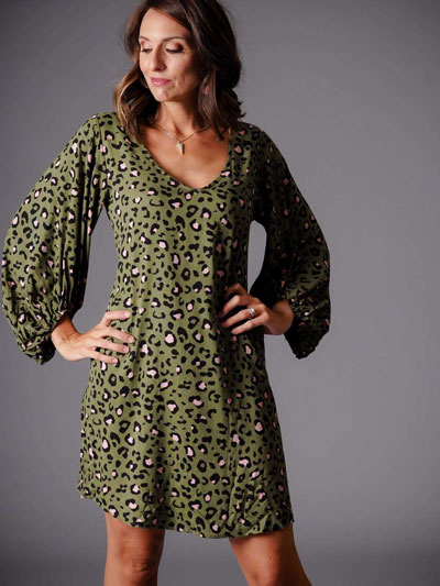 A woman models a green leopard print casual boutique dress