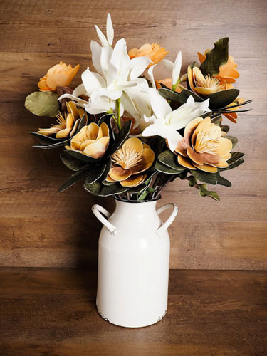 A rustic milk can filled with flowers as an example of farmhouse Easter decor.