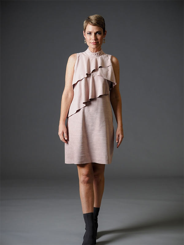 A woman models a ruffled, nude-colored dress as a casual holiday party outfit