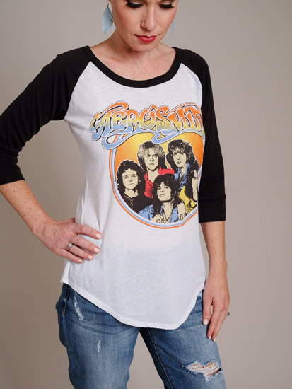 A woman models a baseball-styled rock-and-roll t-shirt as an example of spring outfits for women.