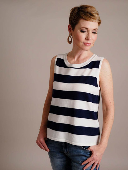 A woman models her white and blue nautical striped shirt for spring outfit inspo.