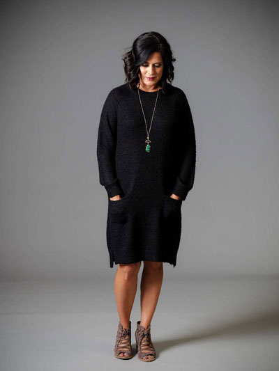 A woman models a casual black sweater boutique dress