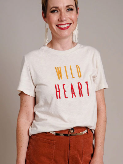 Woman in white “Wild Heart” graphic t-shirt models how to how to wear graphic tees professionally.