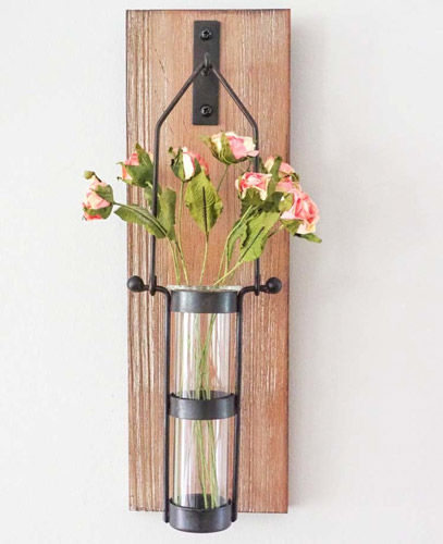 wooden hanging bud vase holding pink flowers